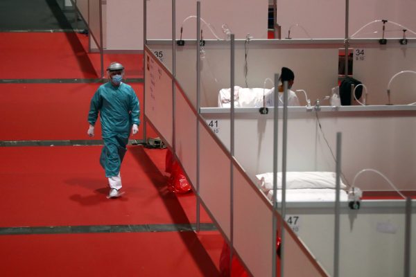 A member of medical personnel walks through the hall of a temporary hospital inside IFEMA conference centre, amid the coronavirus disease (COVID-19) outbreak, in Madrid, Spain, April 2, 2020. REUTERS/Sergio Perez